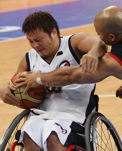 Kyoya Kazuyuki (L) of Japan fights for the ball. Canada beats Japan 75-48 to advance in Men's Wheelchair Basketball preliminary match at the Beijing 2008 Paralympic Games in Beijing on September 10, 2008. 