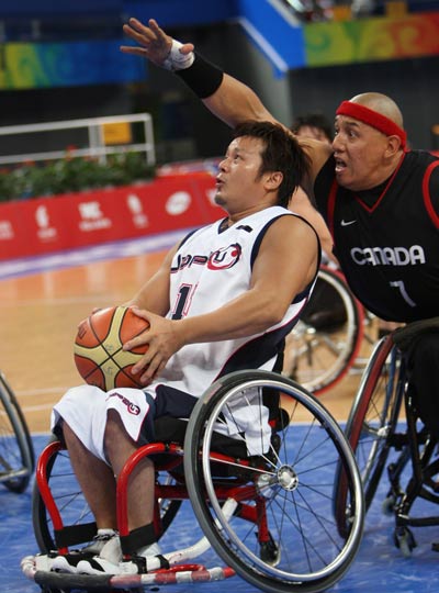 Kyoya Kazuyuki (L) of Japan holds the ball. Canada beats Japan 75-48 to advance in Men's Wheelchair Basketball preliminary match at the Beijing 2008 Paralympic Games in Beijing on September 10, 2008. 