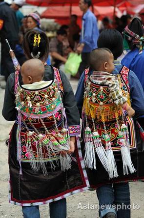 Two ethnic minority women carry their babies on their backs with home-made carriers in Jichang Shui autonomous town, Guizhou province September 7, 2008. [Asianewsphoto]