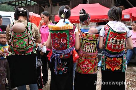 Four ethnic minority women carry their babies on their backs with home-made carriers in Jichang Shui autonomous town, Guizhou province September 7, 2008. [Asianewsphoto] 