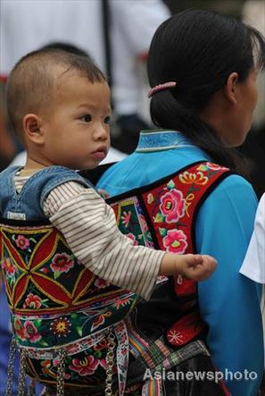 A baby sits in his mother's home-made carrier in Jichang Shui autonomous town, Guizhou province September 7, 2008. [Asianewsphoto] 