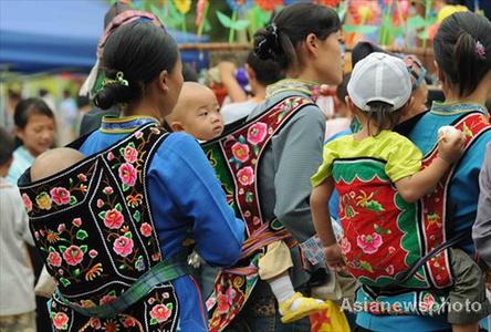 Ethnic minority women carry their babies on their backs with home-made carriers in Jichang Shui autonomous town, Guizhou province September 7, 2008. [Asianewsphoto] 