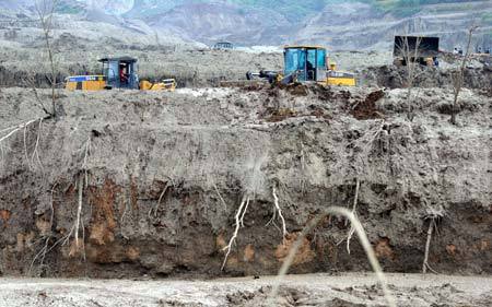 Bulldozers clear mud at the mudslide area in Xiangfen County, North China's Shanxi Province, September 10, 2008. [Xinhua]