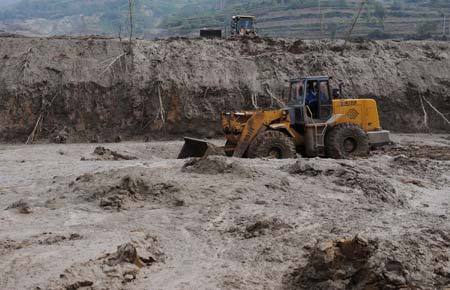 A bulldozer clears mud at the mudslide area in Xiangfen County, North China's Shanxi Province, September 10, 2008. [Xinhua]