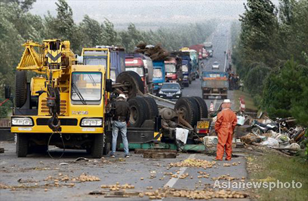 Firefighters clear the site as traffic is halted after a truck collision in Changchun, Jilin province on September 10, 2008.[Asianewsphoto] 
