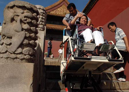 A handicapped woman goes upstairs with the help of a "climbing machine" in the Palace Museum, or the Forbidden City, in Beijing Sept. 10, 2008. Thanks to the obstacle-free facilities for handicapped people, now they can visit scenic sopts here with much more convenience.