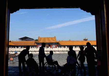 Handicapped people on wheelchairs visit the Palace Museum, or the Forbidden City, in Beijing Sept. 10, 2008. Thanks to the obstacle-free facilities for handicapped people, now they can visit scenic sopts here with much more convenience. 