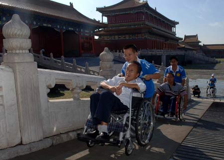 Handicapped people on wheelchairs visit the Palace Museum, or the Forbidden City, with the help of volunteers in Beijing Sept. 10, 2008. Thanks to the obstacle-free facilities for handicapped people, now they can visit scenic sopts here with much more convenience. 