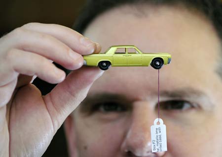 Specialist cataloguer Andy Reed holds a matchbox toy Cadillac valued at three hundred pounds ($525) at Vectis in Thornaby, northern England, September 10, 2008.