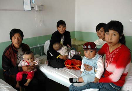 Parents of the babies with kidney stones tell the reporter about their kids' drinking state at a military hospital in Lanzhou, capital of northwest China's Gansu Province, Sept. 11, 2008. 