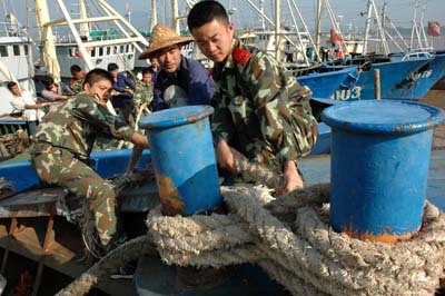 PLA soldiers help local fishermen in Taizhou, east China's Zhejiang Province, protect against typhoon Sinlaku.