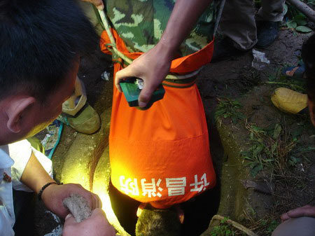 A soldier is lowered head first into a well to rescue a trapped grandmother in a village in Xuchang city in central China's Henan Province on Wednesday, September 10, 2008. [Photo: dahe.cn]