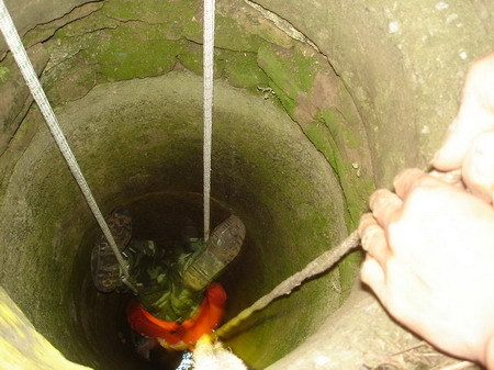 A soldier is lowered head first into a well to rescue a trapped grandmother in a village in Xuchang city in central China's Henan Province on Wednesday, September 10, 2008. [Photo: dahe.cn]