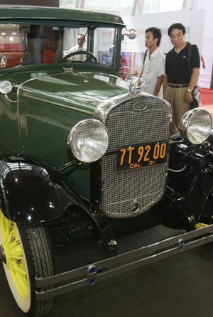 Visitors look at a Ford car made in 1931, during the 2008 Shanghai Import Auto Show in Shanghai, east China, Sept. 11, 2008.[Pei Xin/Xinhua]