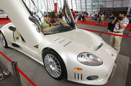 A visitor takes pictures of a sports car during the 2008 Shanghai Import Auto Show in Shanghai, east China, Sept. 11, 2008. [Pei Xin/Xinhua]