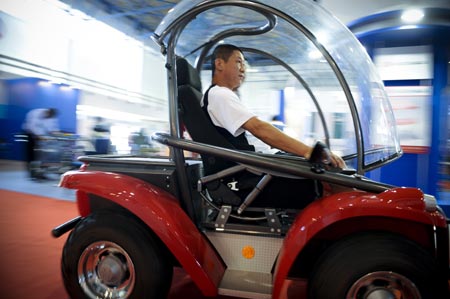 A disabled man tries an electric wheelchair during a visit to an exhibition for the rehabilitative and assistive facilities held in Beijing September 11, 2008. The three-day expo, started on Thursday, will display more than 1,000 types of products for the physically challenged like hearing aids, special vehicles for the disabled, prosthetic limbs and diapers for the paralyzed. (Xinhua/Liu Jie) 