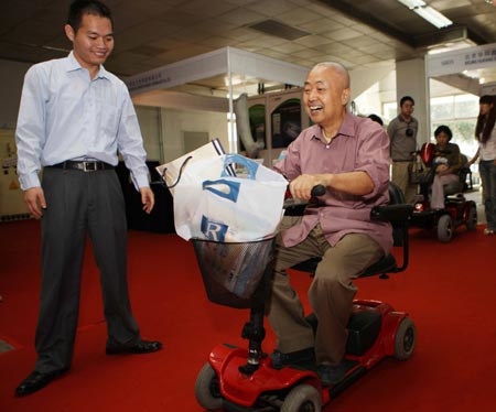 A man tries an electric four-wheel bike during a visit to an exhibition for the rehabilitative and assistive facilities held in Beijing September 11, 2008. The three-day expo, started on Thursday, will display more than 1,000 types of products for the physically challenged like hearing aids, special vehicles for the disabled, prosthetic limbs and diapers for the paralyzed.(Xinhua/Yuan Man)