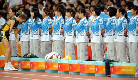Volunteers are seen on standby during a match of the Beijing Paralympic Athletics event at the National Stadium Sept. 10, 2008. Some 44,000 volunteers are serving for the ongoing Beijing 2008 Paralympic Games and 90 percent of them have worked for the Olympic Games last month. 