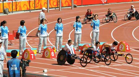Volunteers are seen on standby during a match of the Beijing Paralympic Athletics event at the National Stadium Sept. 11, 2008.
