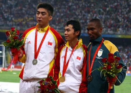 Gold medalist Yang Sen of China (C), silver medalist Fu Xinhan of China (L) and bronze medalist Teboho Mokgalagadi of South Africa react during the awarding ceremony of men's 100m T35 final at the National Stadium，also known as the Bird's Nest, during the Beijing 2008 Paralympic Games in Beijing, Sept. 13, 2008. [Zhang Yanhui/Xinhua]