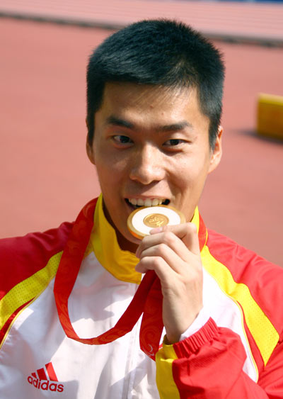 Zhang Lixin kisses his gold medal. (Photo credit: Xinhua)