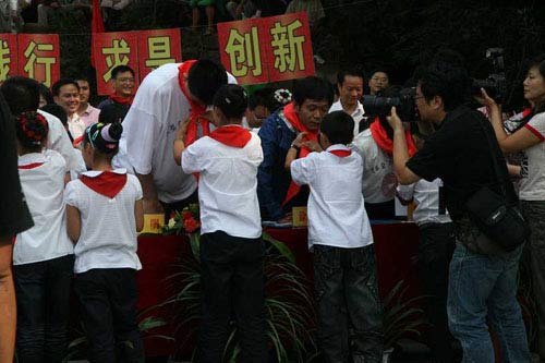 A student from Guangyuan of Sichuan province ties a red scarf around Yao Ming's neck on Sunday, September 14, 2008. [yaofoundation.cn]