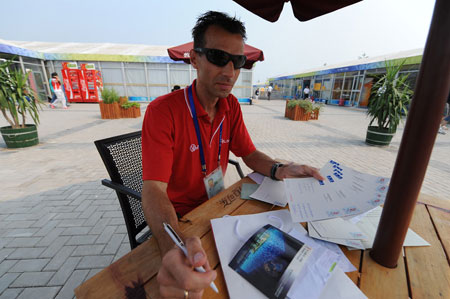 Tomasz Chmurzynski, a Polish paralympian, is busy writing postcards to his family and friends. 