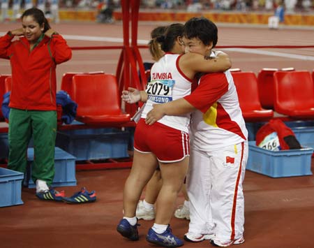 Tunisia's Raoua Tlili and China's Menggen Jimisu (R) congratulate each other after women's shot put F40 final at the National Stadium, also known as the Bird's Nest, during the Beijing 2008 Paralympic Games in Beijing, Sept. 15, 2008.
