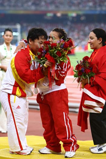 Gold medalist Raoua Tlili of Tunisia (C) congratulates silver medalist Menggen Jimisu (L) as bronze medalist Laila El Garaa of Morocco watches during the awarding ceremony of women's shot put F40 final at the National Stadium, also known as the Bird's Nest, during the Beijing 2008 Paralympic Games in Beijing, Sept. 15, 2008. [Xinhua]