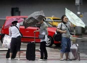 People struggle with their umbrellas against strong winds as Typhoon Sinlaku hits Taipei September 13, 2008.[Xinhua/Reuters]