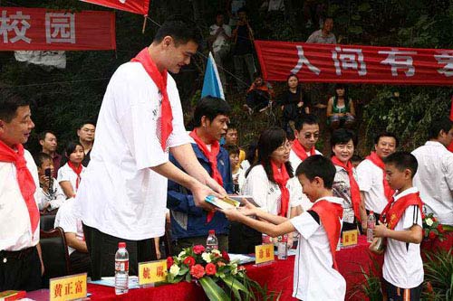 NBA star Yao Ming hands out books to pupil students in Guangyuan, Sichuan Province on September 14, 2008. [Photo: yaofoundation.cn] 