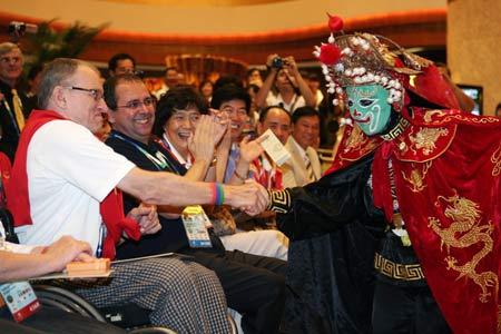 A Chuanju Opera player shakes hands with a foreign audience during the Mid-Autumn soiree in Beijing, capital of China, September 14, 2008. Some officials and athletes of Beijing Paralympic Games and some foreign guests attended a soiree on Sunday night to celebrate the Mid-Autumn Festival, a traditional Chinese festival for family reunions, by enjoying traditional Chinese culture. (Xinhua Photo)