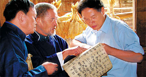 Pan Chaolin (right) examines a document with the help of two Shuishu masters. 