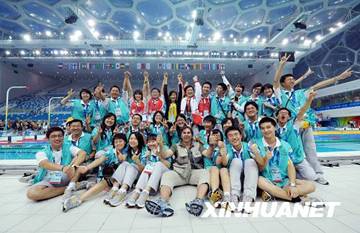 Volunteers, staff members and reporters take a group photo after a successful finale to the competitions at the Water Cube on September 15. [Xinhua]