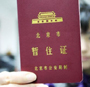 A woman shows her Temporary Residence Permit.
