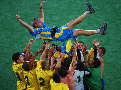 Players of Ukraine lift their coach Sergiy Ovcharenko (top) after they won.[Guang Niu/Getty Images]