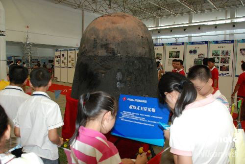 Visitors watch a recoverable satellite at an aerospace exhibition held in Guilin on Friday, September 12, 2008. 