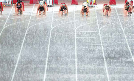  Dashing in the rain: Sprinters take their marks in a downpour at the Bird's Nest yesterday.
