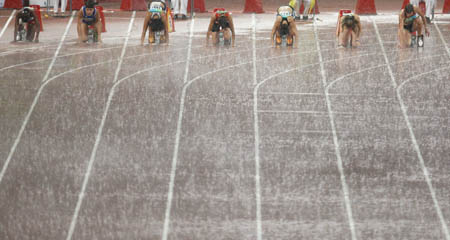 Athletes get ready to set off in the heavey rain at the National Stadium, also known as the Bird's Nest, during the Beijing 2008 Paralympic Games in Beijing, Sept. 16, 2008. 