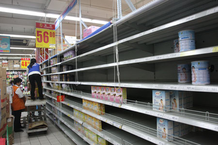 Supermarket staffs remove formula milk products found to be contaminated with melamine off the shelves in Harbin, Northeast China's Heilongjiang Province, September 17, 2008. 