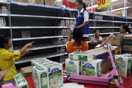 Supermarket staffs remove formula milk products found to be contaminated with melamine off the shelves in Harbin, northeast China's Heilongjiang Province, September 17, 2008.