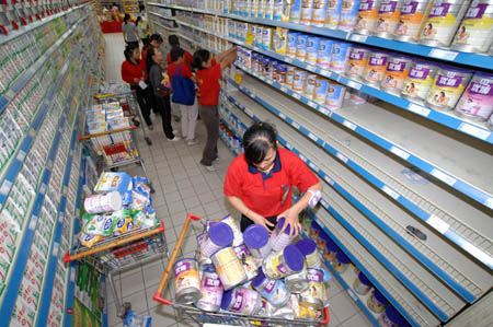 Supermarket staffs remove milk formula products found to be contaminated with melamine off the shelves in Hefei, east China's Anhui Province, September 17, 2008. 