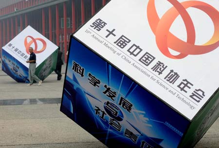 A man walks past cubes promoting the 10th annual meeting of the China Association for Science and Technology (CAST) in Zhengzhou, capital of central China&apos;s Henan Province, Sept. 17, 2008. The annual meeting, attracting more than 10,000 scientific workers including over 100 academicians of the Chinese Academy of Sciences and the Chinese Academy of Engineering, kicked off on Wednesday.