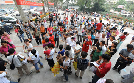 Parents and their infants queue for medical treatment at the Children's Hospital of Zhengzhou in Zhengzhou, capital of central China's Henan Province, Sept. 17, 2008. According to the data released by the health bureau of Zhengzhou City, up to 8 a.m. of Sept. 17, 261 cases of kidney stones were diagnosed among 3,244 infants drinking Sanlu's tainted baby milk powder. The chemical melamine was added to the milk as it was believed to have helped to increase protein content. (Xinhua/Zhao Peng)