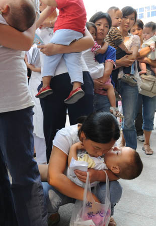 Parents take their children for medical treatment at the Children's Hospital of Zhengzhou in Zhengzhou, capital of central China's Henan Province, Sept. 17, 2008. According to the data released by the health bureau of Zhengzhou City, up to 8 a.m. of Sept. 17, 261 cases of kidney stones were diagnosed among 3,244 infants drinking Sanlu's tainted baby milk powder. The chemical melamine was added to the milk as it was believed to have helped to increase protein content. (Xinhua/Zhao Peng) 