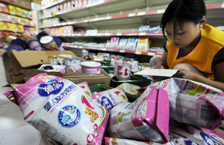 A supermarket staff registers the returned Sanlu brand milk powders in a supermarket in in Hefei, capital of east China's Anhui Province Sept. 17, 2008. [Chen Yehua/Xinhua] 