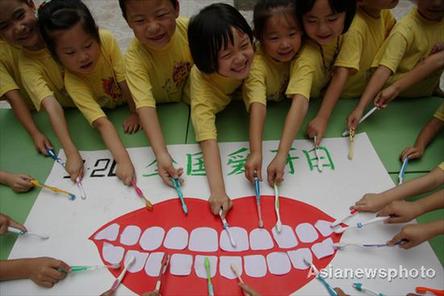 Pupils at Shizhong District Experimental Primary School play teeth-brushing games in Zaozhuang, Shangdong province on September 18, 2008. The country's Teeth Care Day falls on September 20, 2008. [Asianewsphoto] 