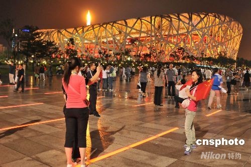 Audiences take photos with the National Stadium or Bird's Nest at night, September 16th, 2008. [Photo: cnsphoto] 