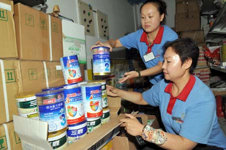 Saleswomen check the returned Sanlu brand milk powders in a supermarket in Yinchuan, capital of northwest China's Ningxia Hui Autonomous Region Sept. 17, 2008. [Liu Quanlong/Xinhua]  