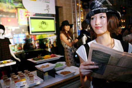 A fashion model helps to recommend at a booth of cantonese cuisine during 2008 Autumn/Winter Food Fair in Shanghai, China on Sep. 17, 2008. Some 150 chefs participated in the fair to show their unique cuisine. (Xinhua/Zhang Ming)